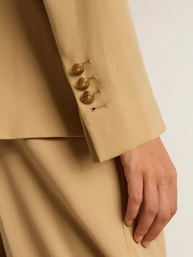 Americana de doble botonadura para mujer en color arena con botones heráldicos dorados