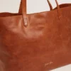 Bolso Pasadena en piel martillada brillante de color beige con logotipo dorado en el frente