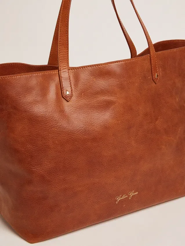 Bolso Pasadena en piel martillada brillante de color beige con logotipo dorado en el frente