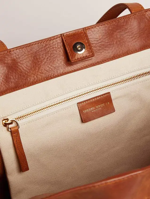 Bolso Pasadena en piel martillada brillante de color beige con logotipo dorado en el frente