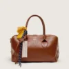 Bolso Vita mediano en piel color marrón claro con dijes y detalles plateados