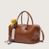 Bolso Vita mediano en piel color marrón claro con dijes y detalles plateados