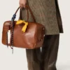 Bolso Vita mediano en piel color marrón claro con dijes y detalles plateados