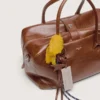 Bolso Vita mediano en piel color marrón claro con dijes y detalles plateados