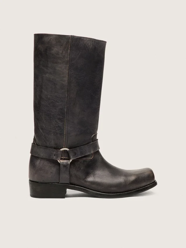 Botas moteras altas para mujer en cuero negro con correa y hebilla plateada