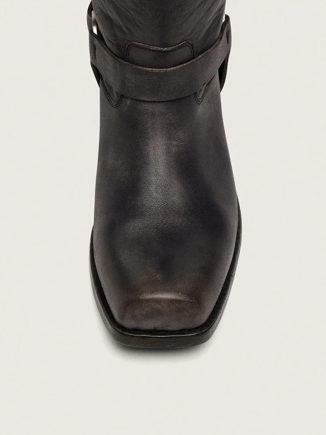 Botas moteras altas para mujer en cuero negro con correa y hebilla plateada