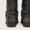 Botas moteras altas para mujer en cuero negro con correa y hebilla plateada