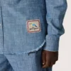 Camisa unisex Journey de cambray de algodón azul claro con dobladillo con flecos y parche bordado