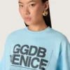 Camiseta corta para mujer en jersey de algodón azul claro con estampado gráfico