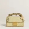 Colgante con forma de bolso de latón dorado con cristales