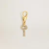 Colgante con forma de llave de latón dorado con cristales