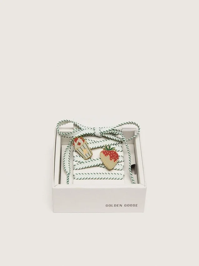 Cordones blancos de pieles con bordado verde bosque y broches de fresa