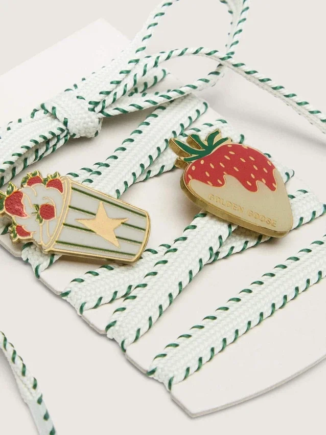 Cordones blancos de pieles con bordado verde bosque y broches de fresa
