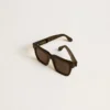 Gafas de sol Jamie de estilo cuadrado con marco negro y logotipo dorado