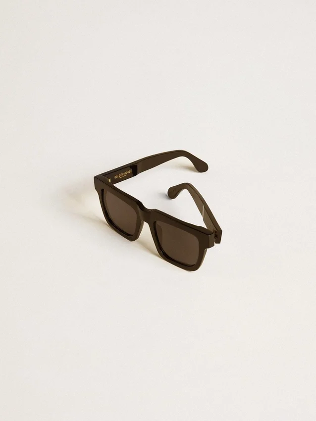 Gafas de sol Jamie de estilo cuadrado con marco negro y logotipo dorado