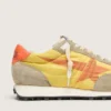 Marathon para mujer con parte superior de nylon amarillo y estrella naranja