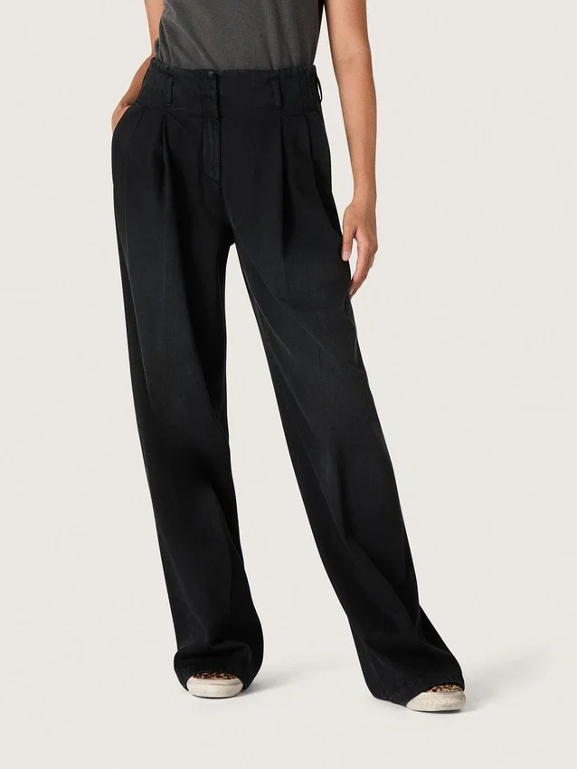 Pantalones de mujer en denim de algodón negro con acabado desgastado