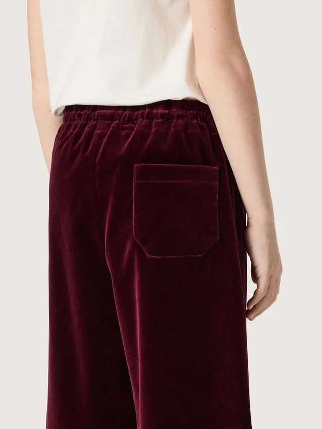 Pantalones para niñas de color burdeos con efecto terciopelo y bolsillo trasero