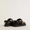 Sandalia Lucy para mujer en cuero negro brillante con hebilla de metal dorado