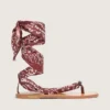 Sandalias planas para mujer con estampado de paisley color burdeos y detalle de joya