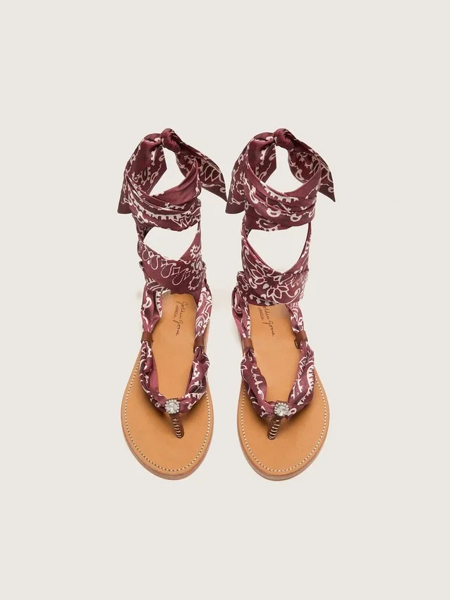 Sandalias planas para mujer con estampado de paisley color burdeos y detalle de joya