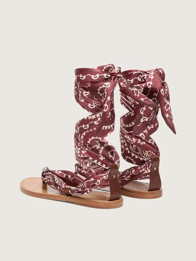 Sandalias planas para mujer con estampado de paisley color burdeos y detalle de joya
