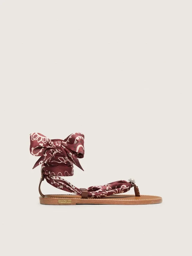Sandalias planas para mujer con estampado de paisley color burdeos y detalle de joya