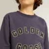 Sudadera azul violeta con el letrero de golden goose en el frente