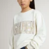 Sudadera blanca para niñas con letras doradas multicolores en el frente
