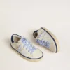 Super-Star Junior en cuero blanco con lengüeta de talón de gamuza azul