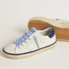 Super-Star Junior en cuero blanco con lengüeta de talón de gamuza azul