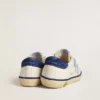 Super-Star Junior en cuero blanco con lengüeta de talón de gamuza azul