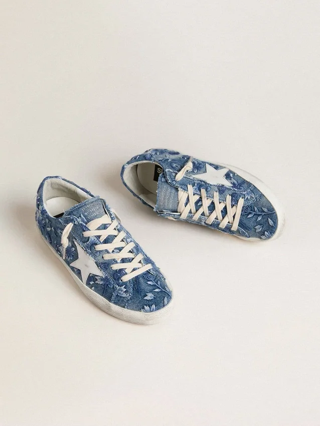 Super-Star LTD para mujer en denim azul claro con una estrella de cuero blanco y flores bordadas