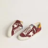Super-Star para hombre en gamuza rojo ladrillo con estrella de cuero blanco y lengüeta en el talón con estampado animal