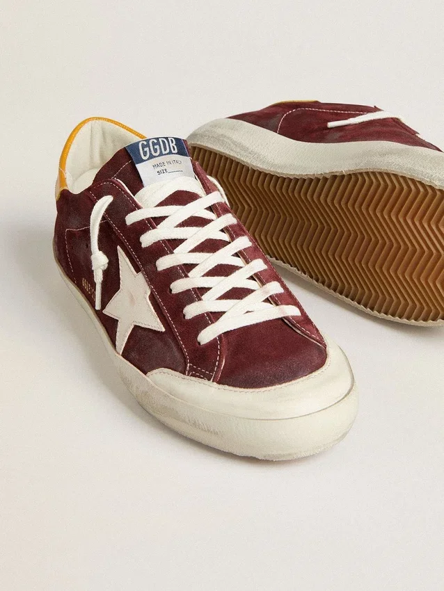 Super-Star para hombre en gamuza rojo ladrillo con estrella de cuero blanco y lengüeta en el talón con estampado animal