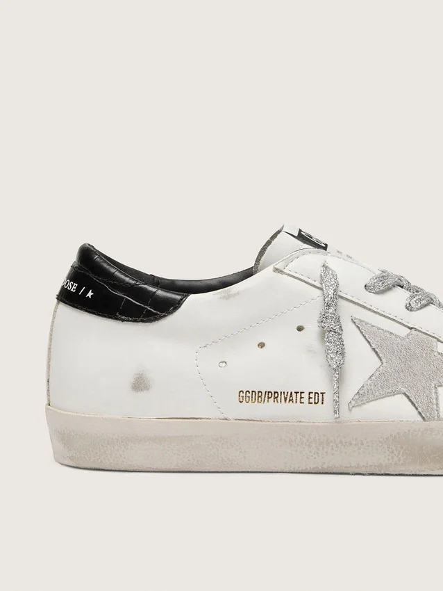 Super-Star para mujer con estrella de gamuza blanca y lengüeta en el talón de cuero negro con estampado de cocodrilo