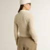 Suéter corto de cuello redondo en lana beige con cristales por toda la prenda