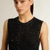 Top de malla negra con lentejuelas y detalles en contraste
